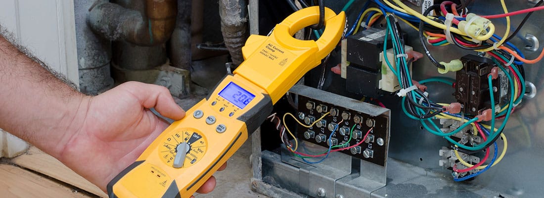 HVAC technician checking the amperage on a residential heat pump